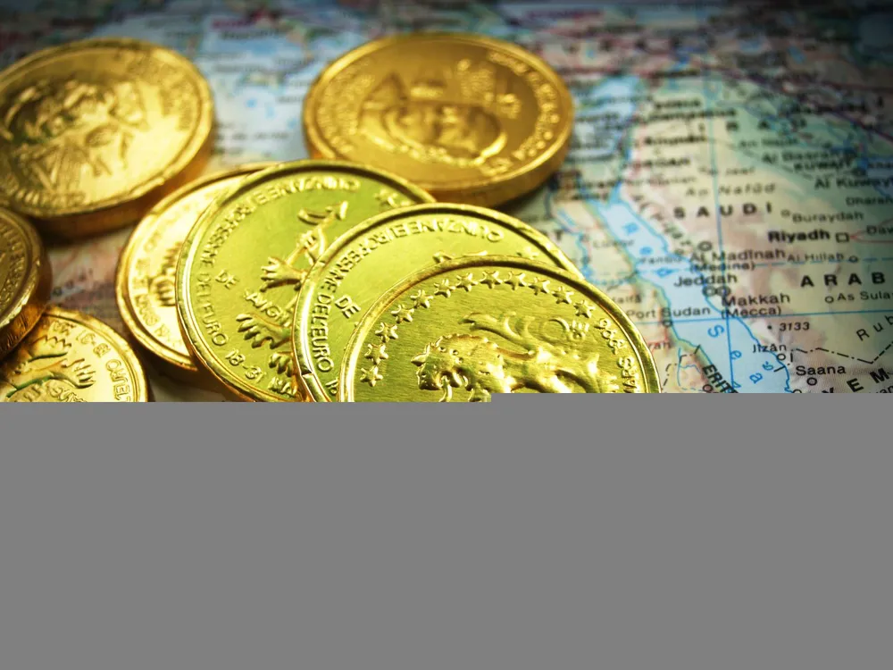 Pièces d'or empilées sur une carte du monde